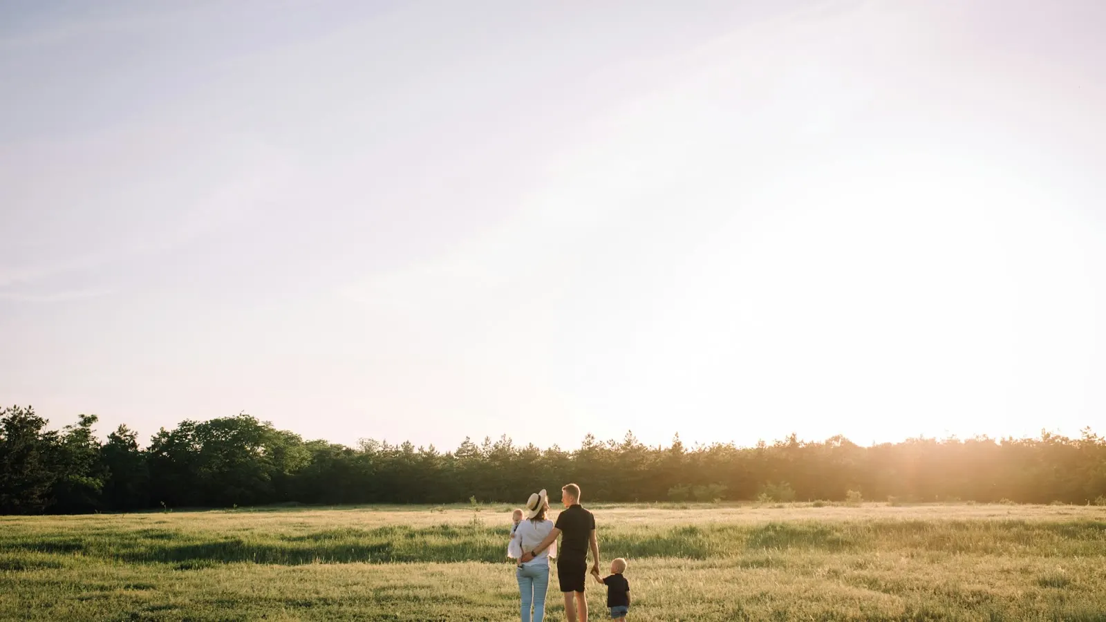 A family walking together across a sunlit field